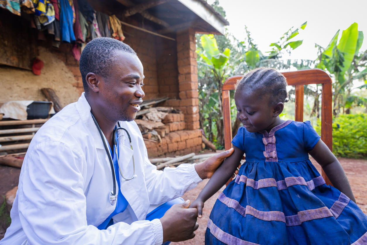 doctor checking a young girl who is a patient outside